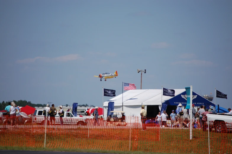 an airplane flying through the air with people in the background