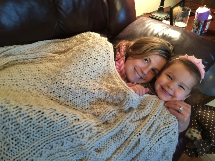 a man sitting next to two children under a blanket