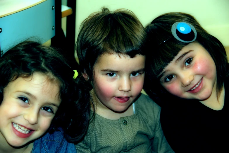 three little girls sitting together looking up