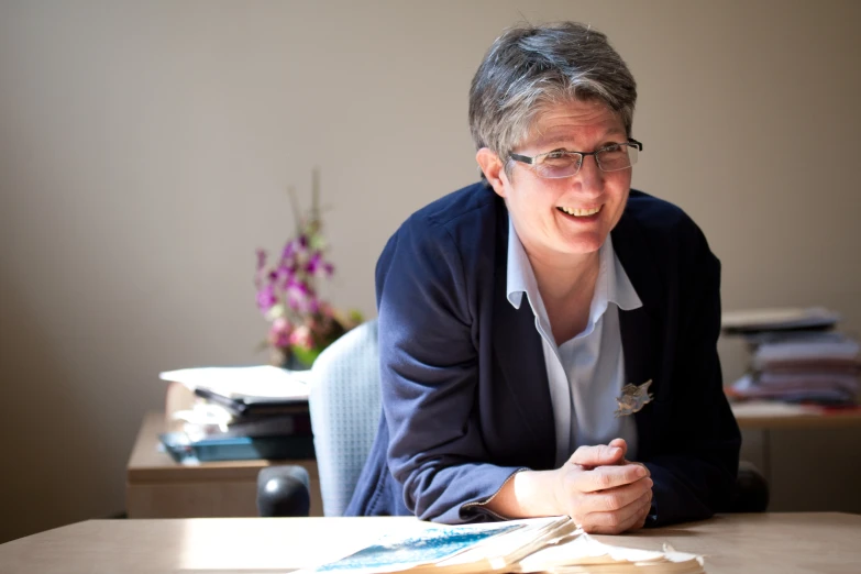 a woman is sitting at the table and smiling