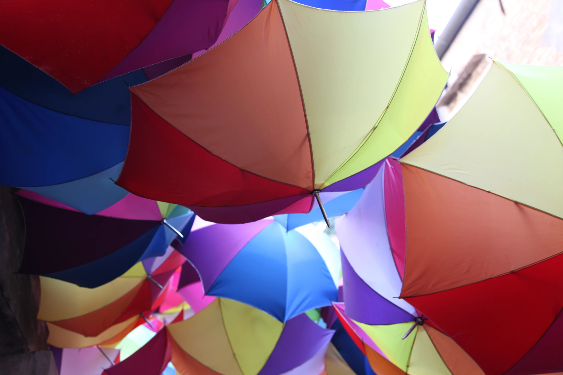 many umbrellas are hanging on a building