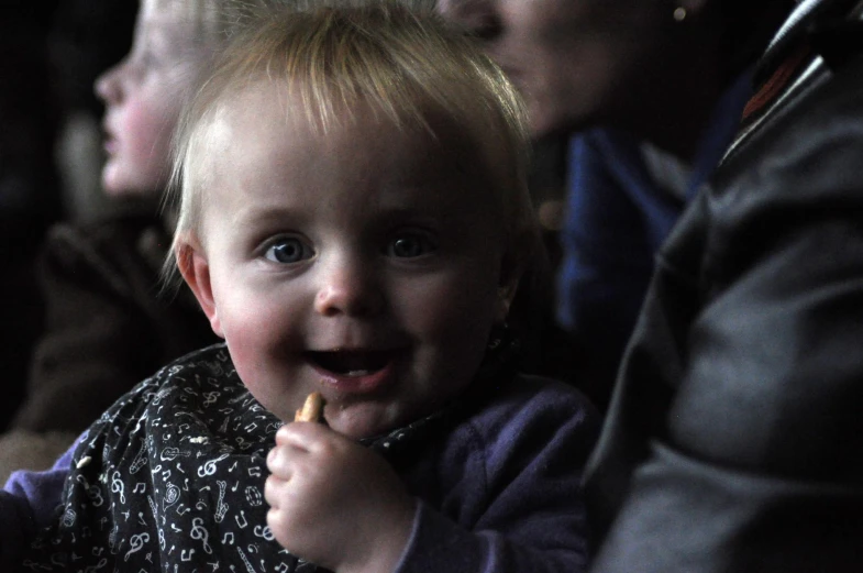 a small child holds on to some food