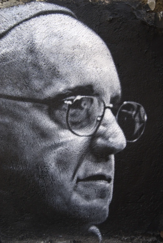 a mural of an old man with glasses painted on the side of a building