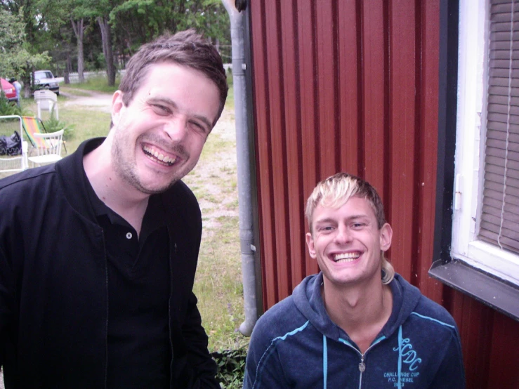 two young men are standing next to each other