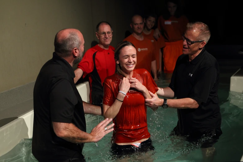 group of people greeting a man and woman in a pool