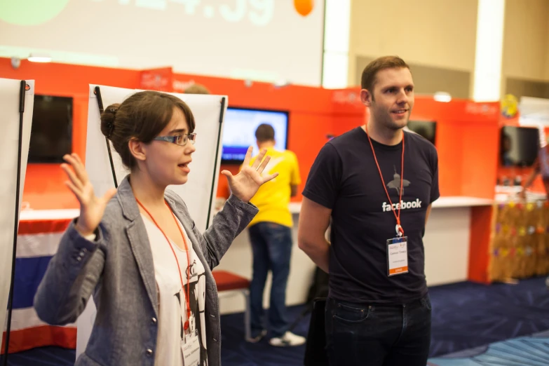 two people are standing and playing games at the computer convention