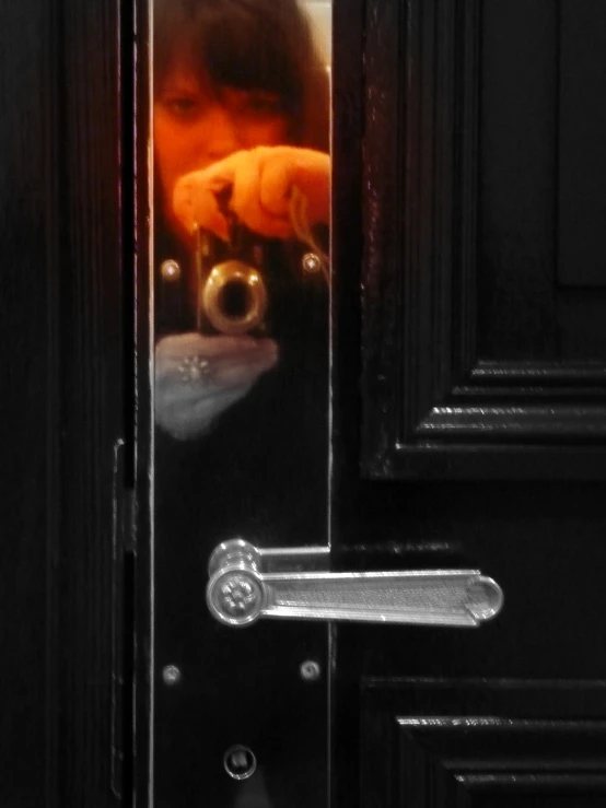 a young child peeking in the door at a stuffed animal