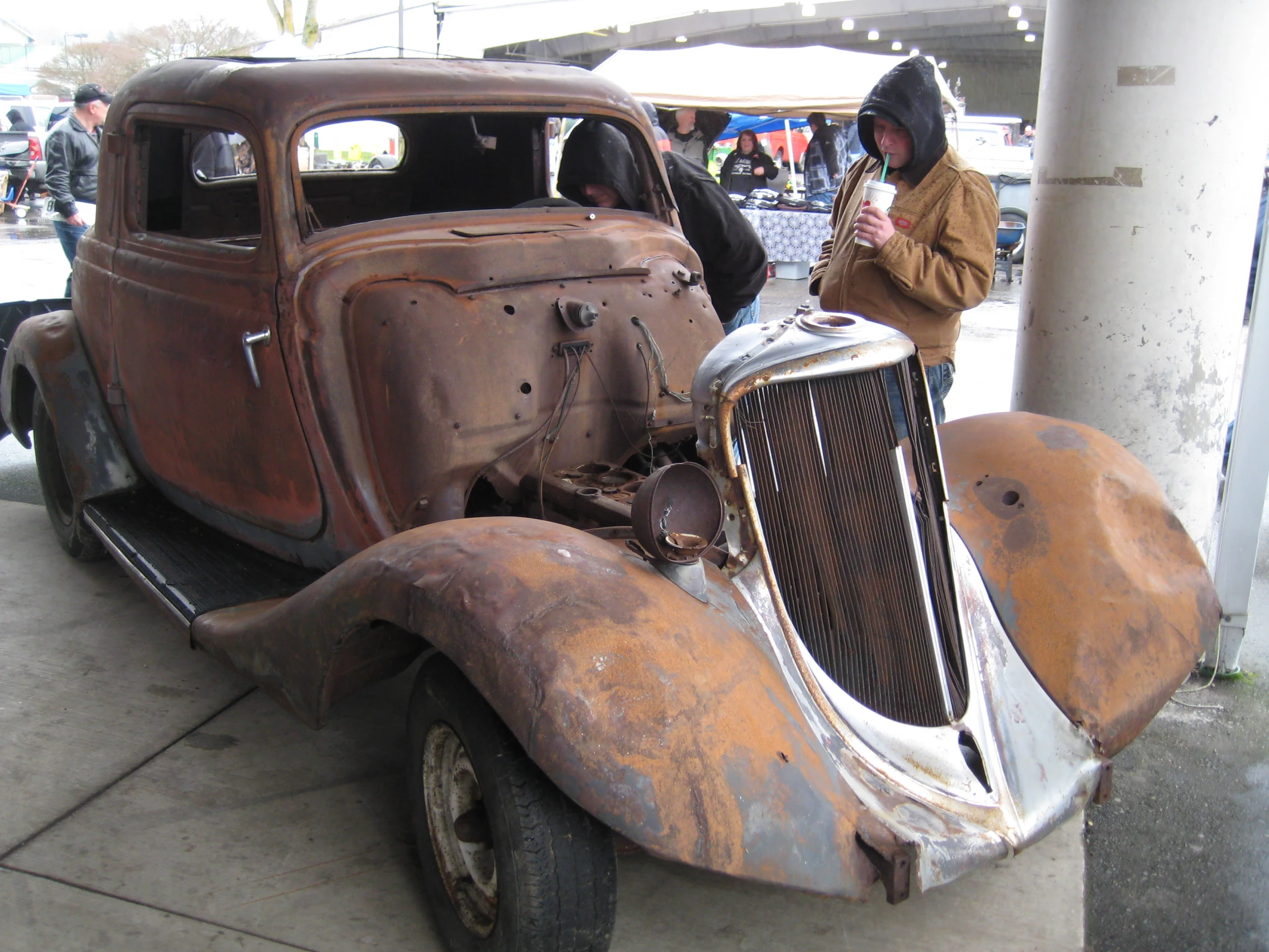 an old time looking car sitting in front of a building