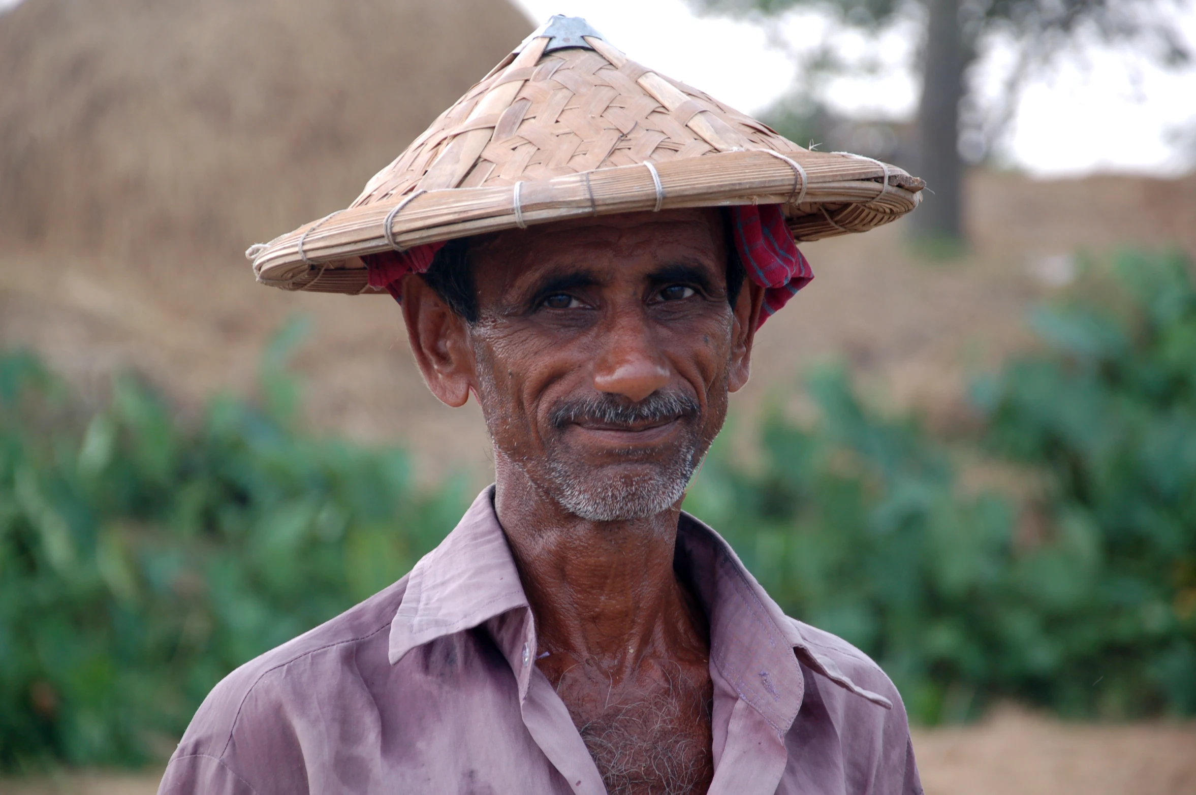 a man in a hat with hair hanging over his head