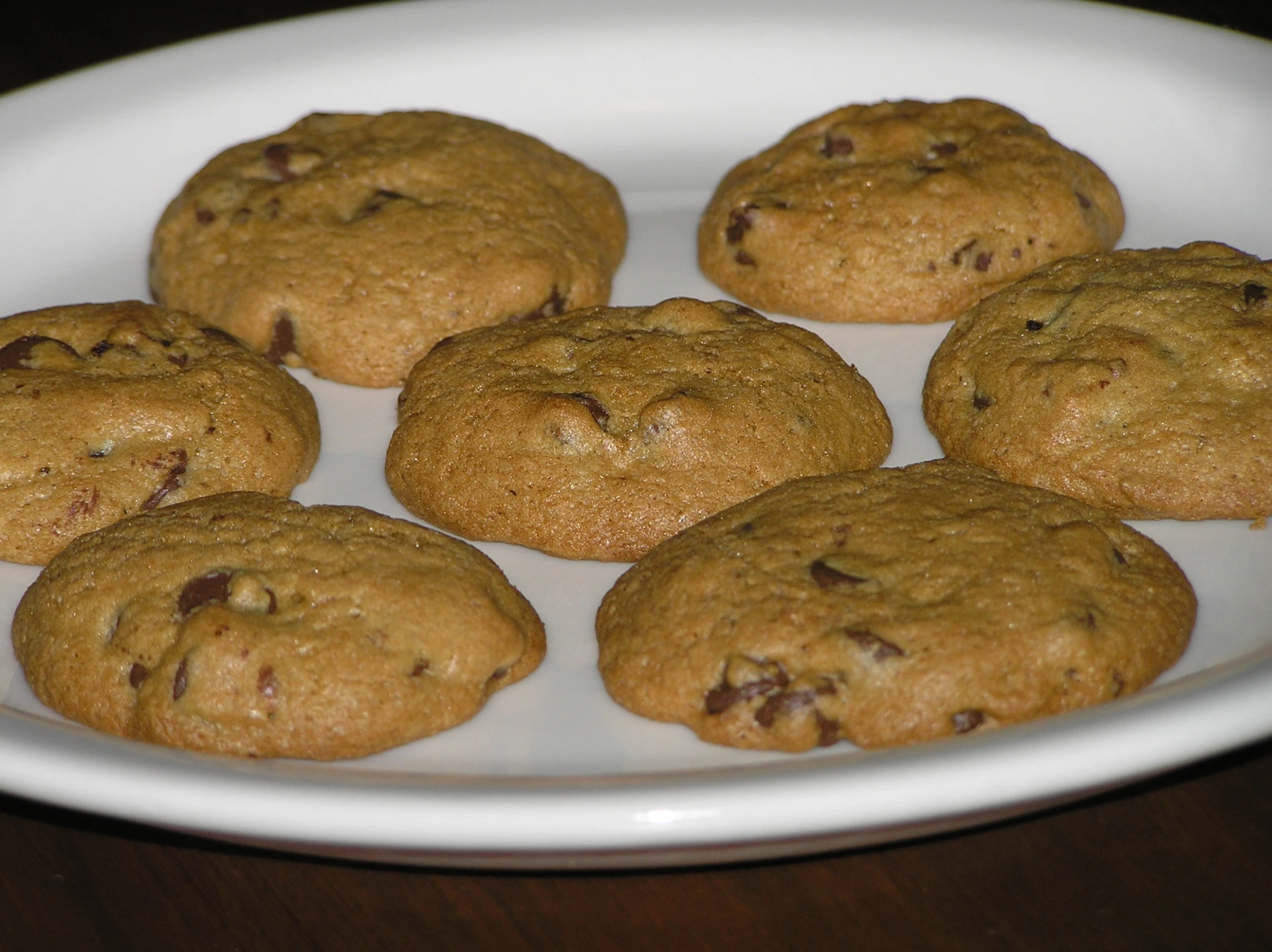 a plate with six cookies on it sitting on a wooden table