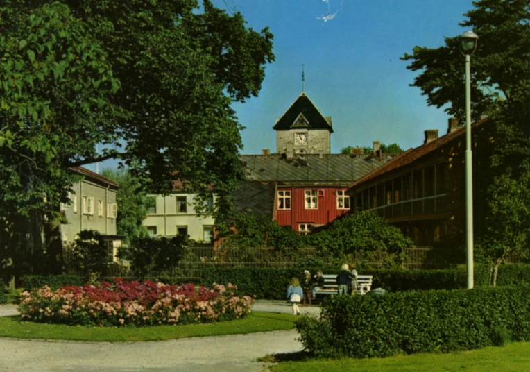 an old house with two people sitting on a bench