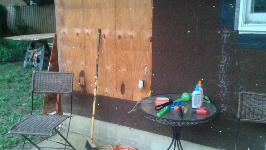 a table and chairs with tools outside a wooden door