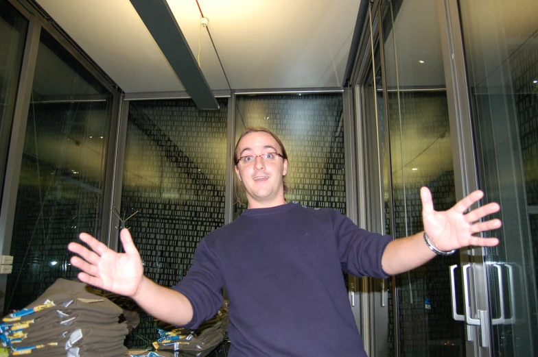 man with outstretched hands in front of a window