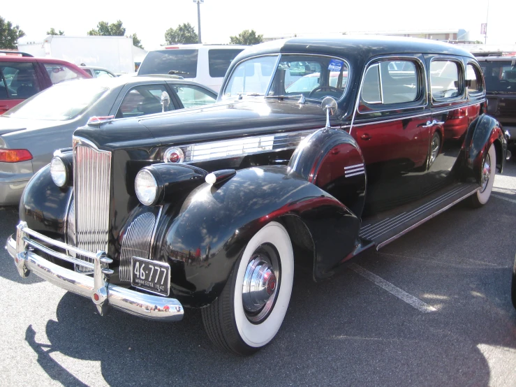 black vintage car in parking lot with other vehicles
