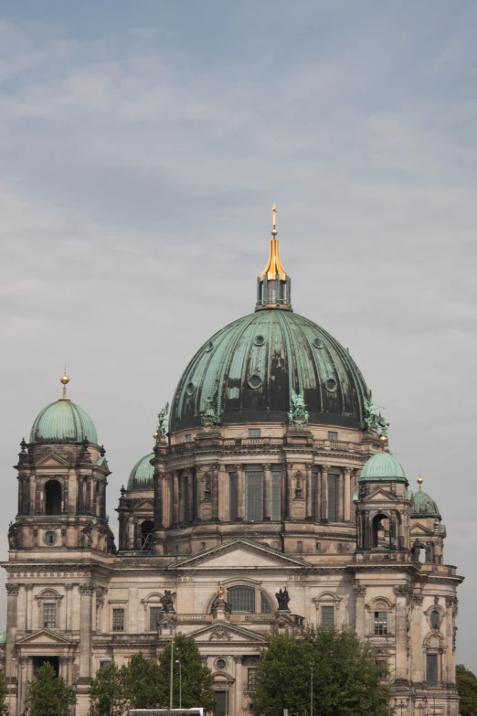 the top of an old building with two green dome domes