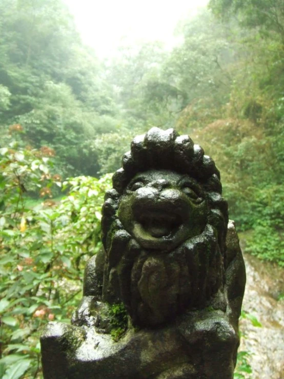 a statue made from concrete in front of a trail