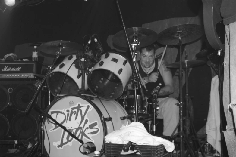 a man is sitting behind two drums in the dark