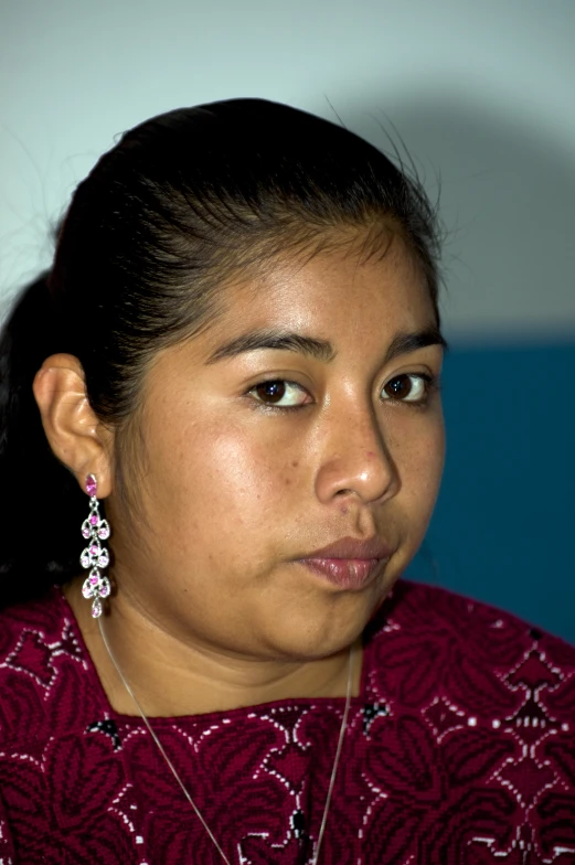 a woman wearing ear wires, looks off into the distance