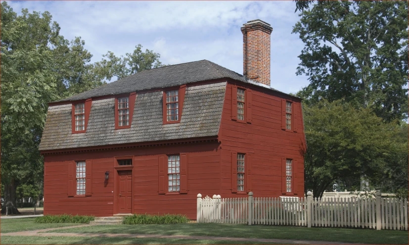 a red building with a fence and trees in front of it