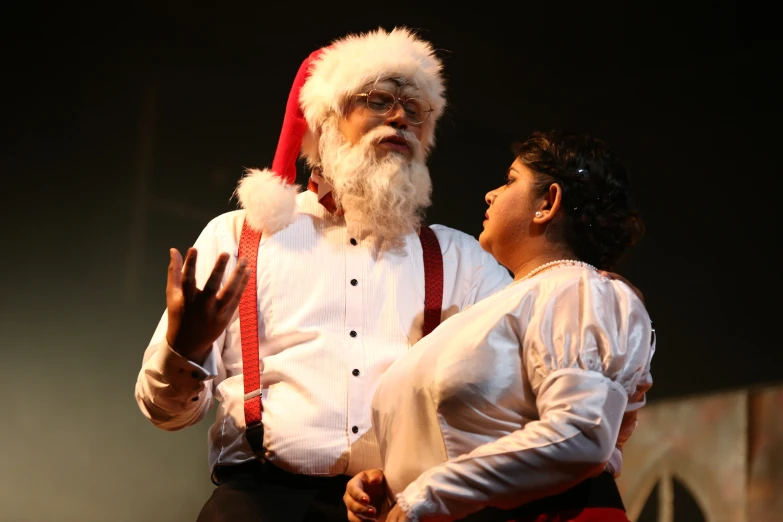 a woman and man dressed up in santa costumes