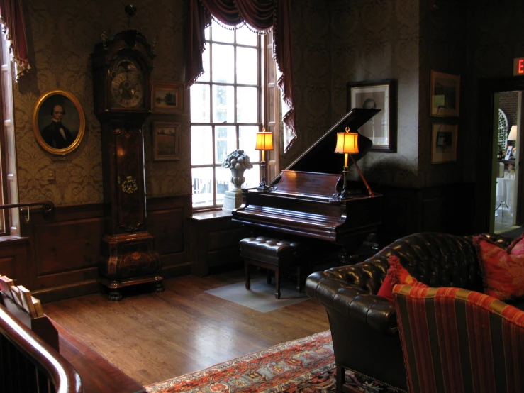 a chair, piano, clock and windows in a dark room