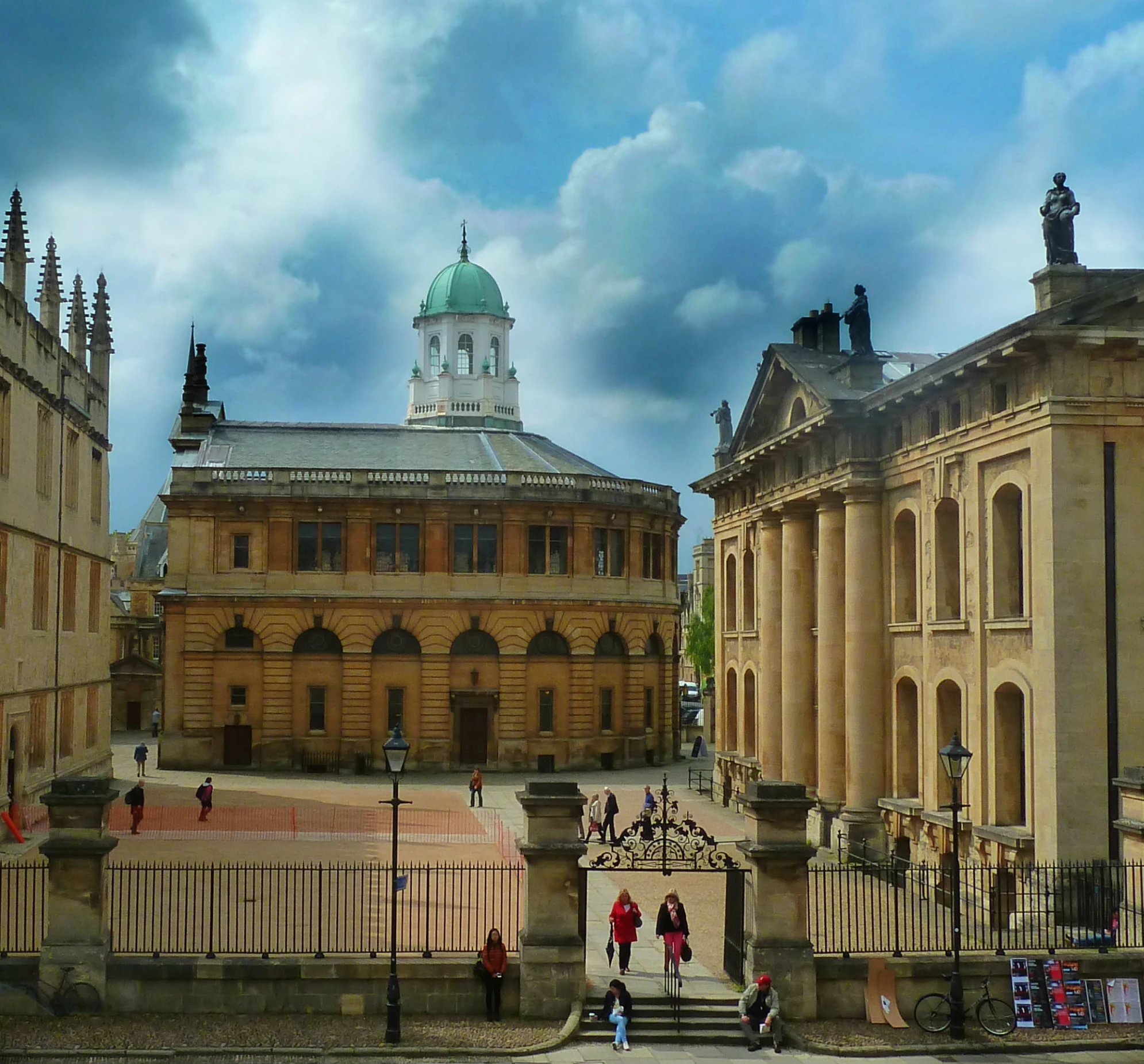 a building with a sky background, and some people walking