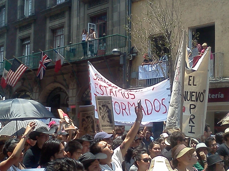 people on a city street holding signs and umbrellas