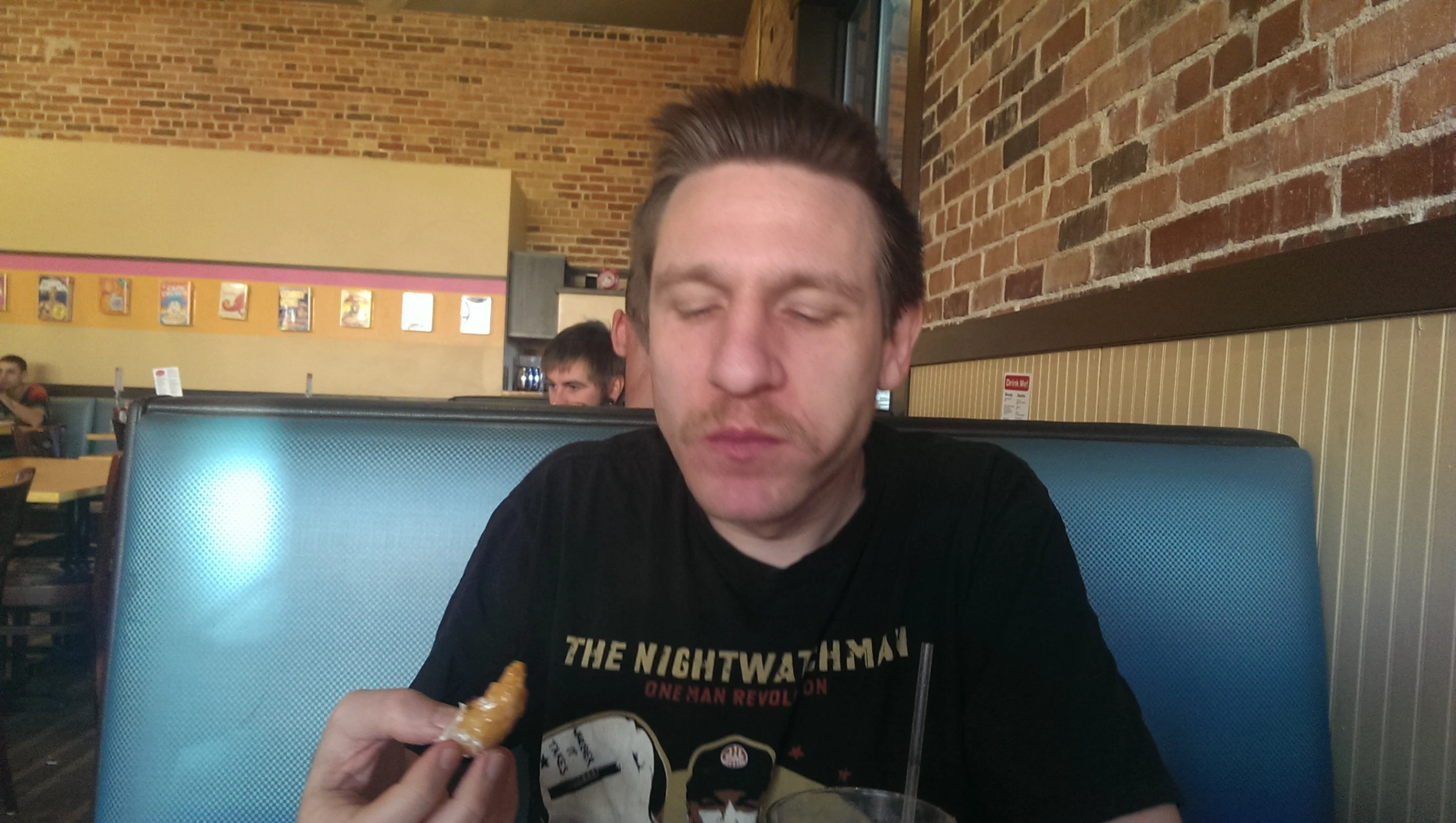 a man eats a doughnut at a restaurant