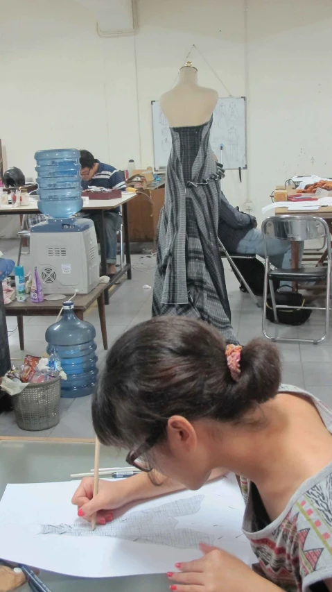 a woman writing on paper in a fashion studio