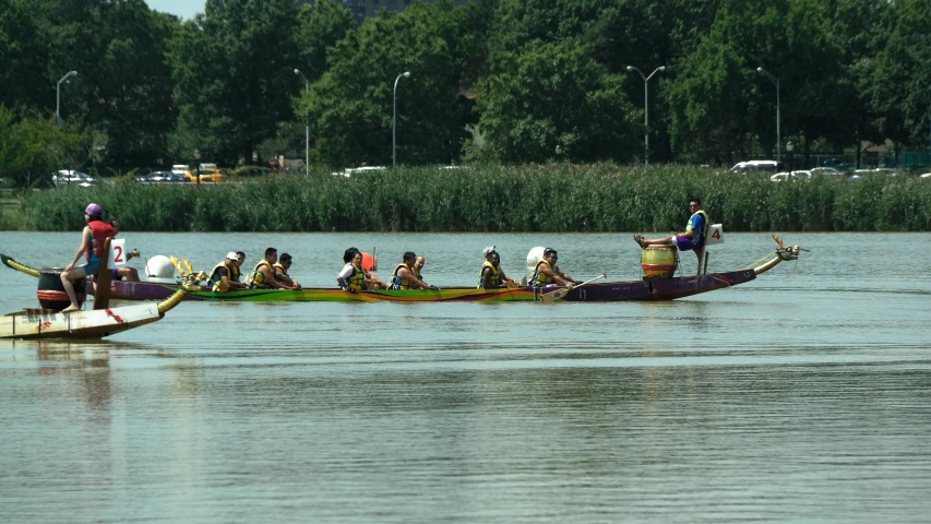 a large long canoe filled with people in the water