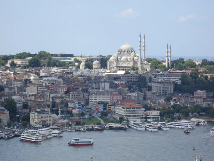 a very long bridge with boats sitting in it and a huge city behind it