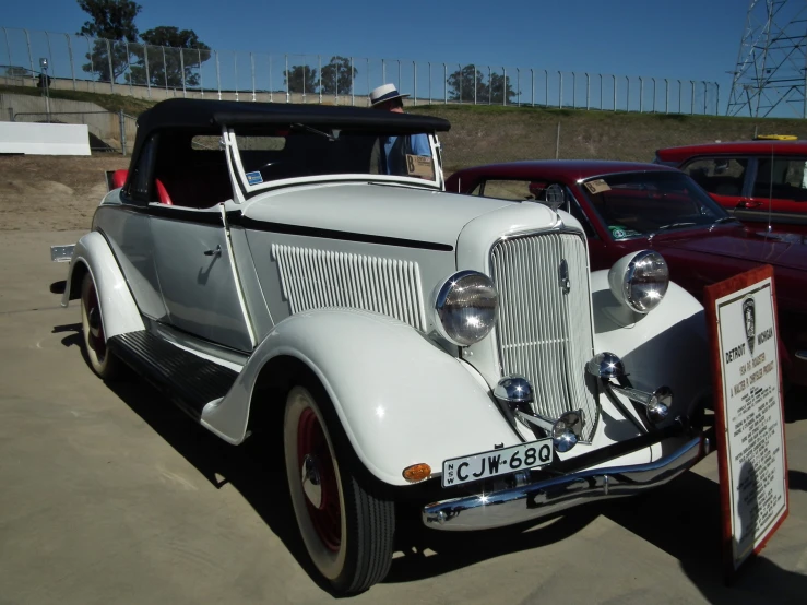 an old style car in the middle of a parking lot