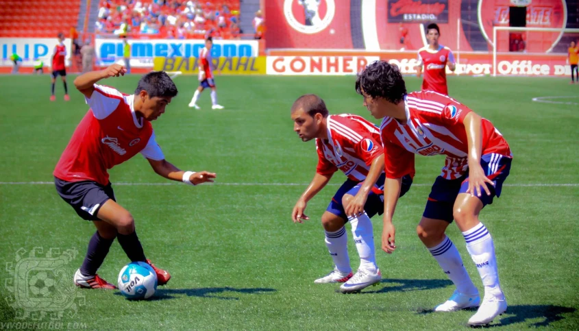 three young men playing a game of soccer