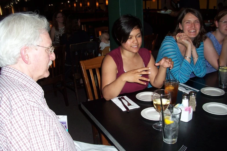 a group of women sitting around a table with drinks