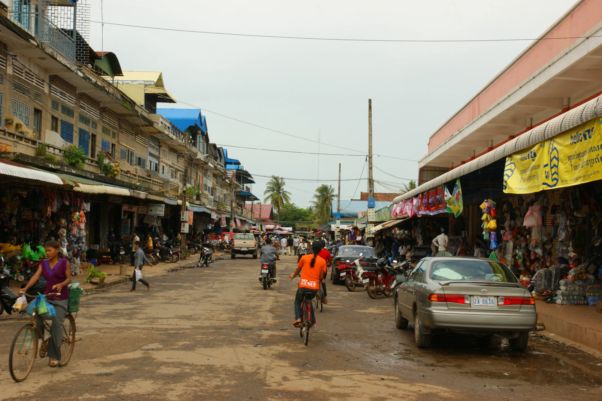 a city street that has many people and parked cars