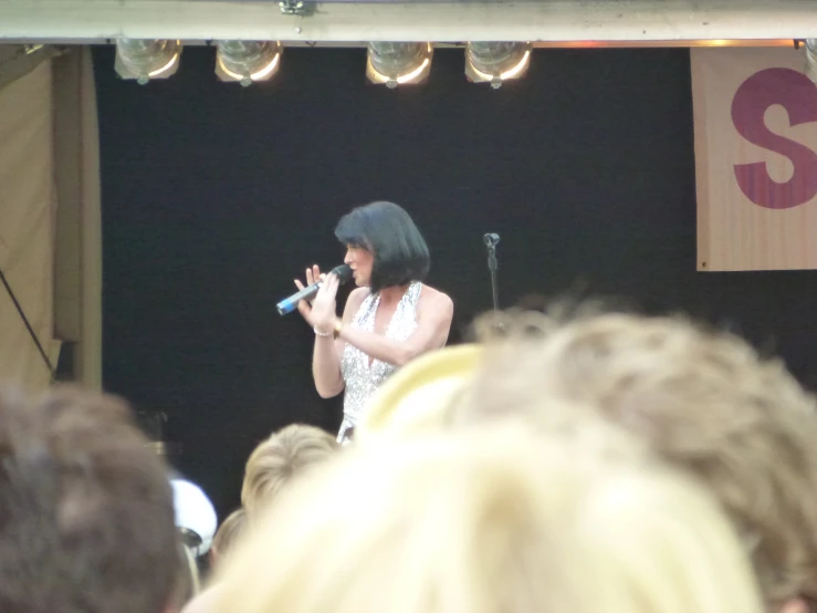 a woman standing on a stage holding a microphone