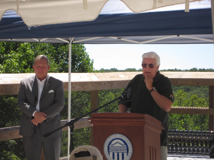 two people are standing behind a podium with a microphone