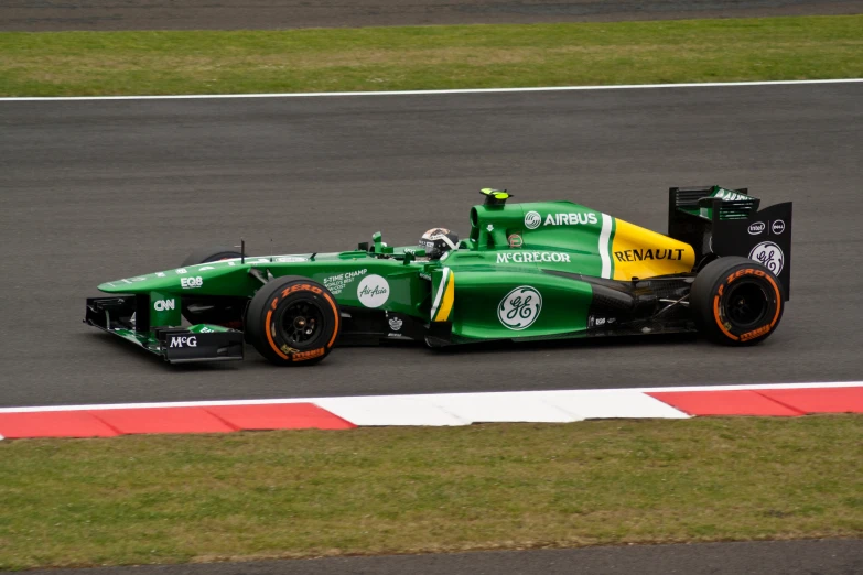 a green race car is racing down a track