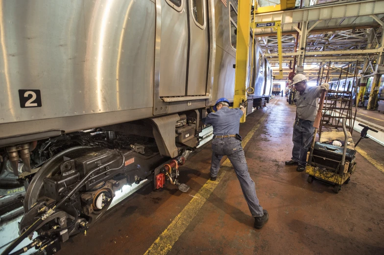 two men working on the side of a train