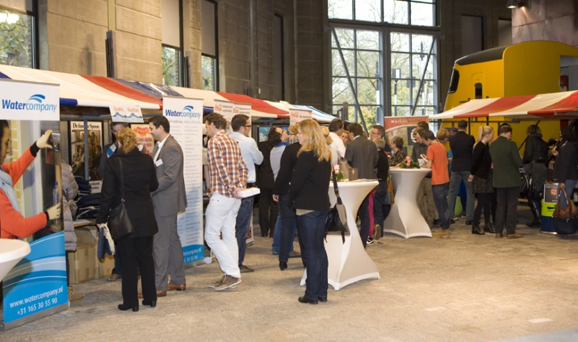 people standing under tents next to tables