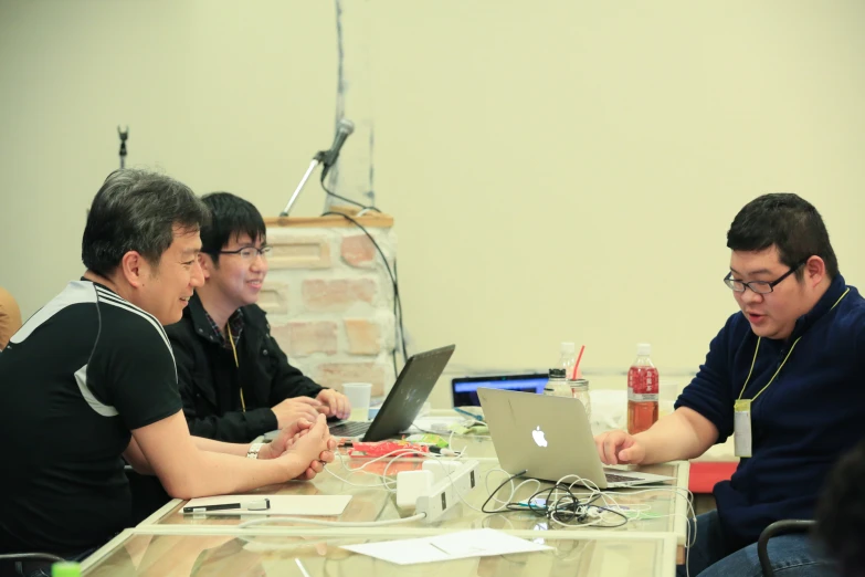 three men sitting down and working on their computers