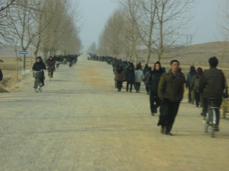 people walk and bicycles are being driven by pedestrians