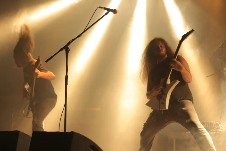 two musicians in front of some lights on a stage