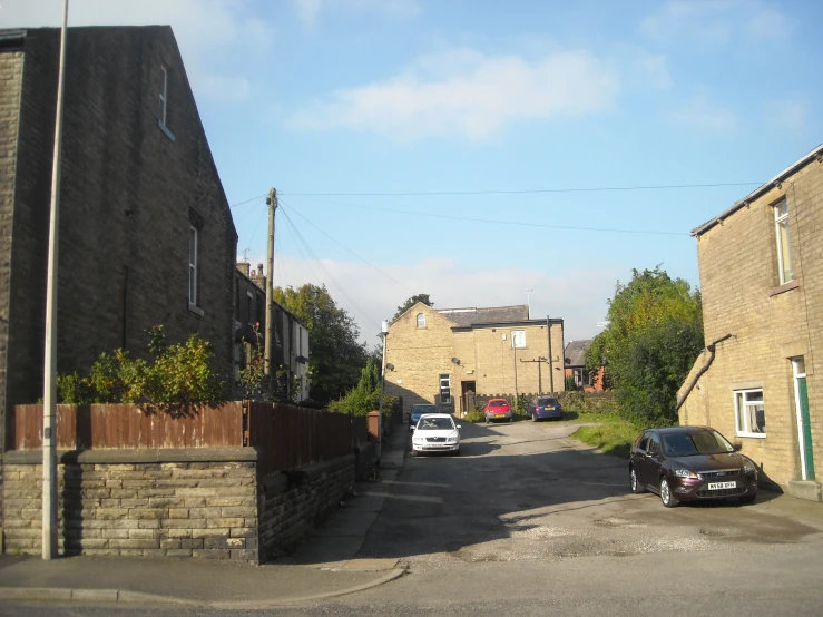 cars parked along the sidewalk in front of the buildings