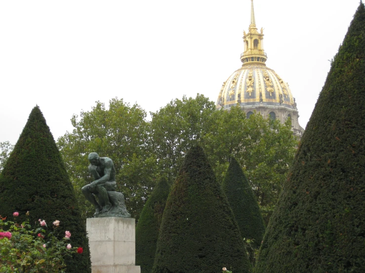 there is a statue in the center of these hedges