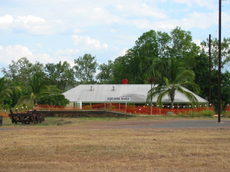 a view of a white farm building with many trees