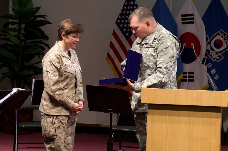 a woman in military uniform standing in front of a podium