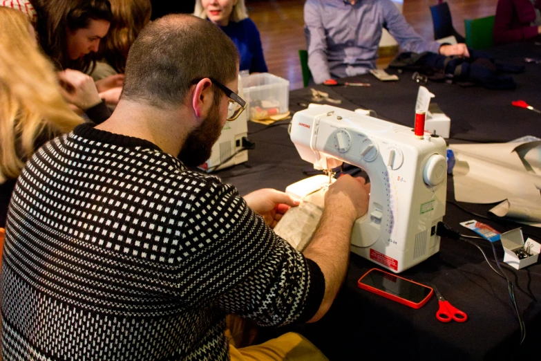 a man is using a sewing machine on a table