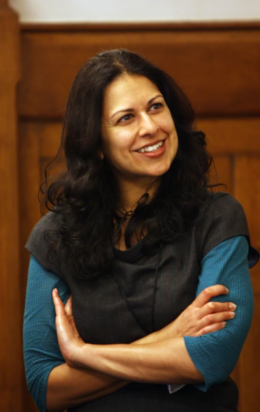 a smiling woman with her arms crossed in front of the camera