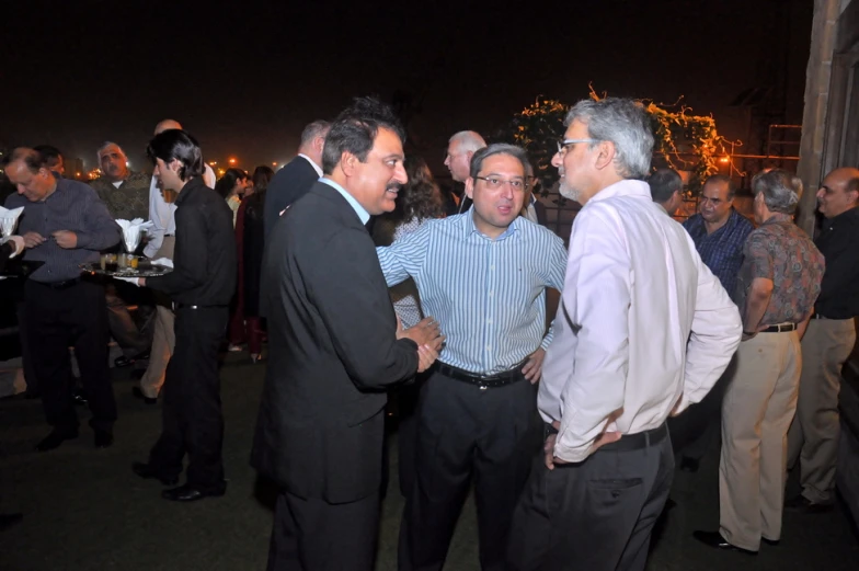 two men talking to one another in a room